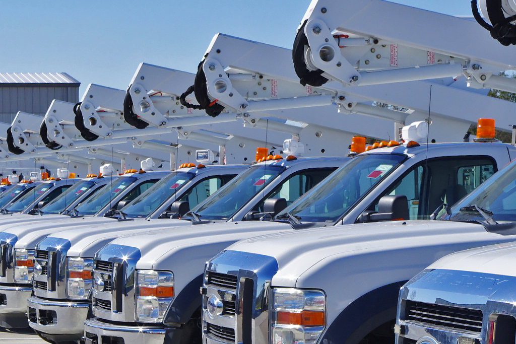 Fleet of parked trucks with lifts.